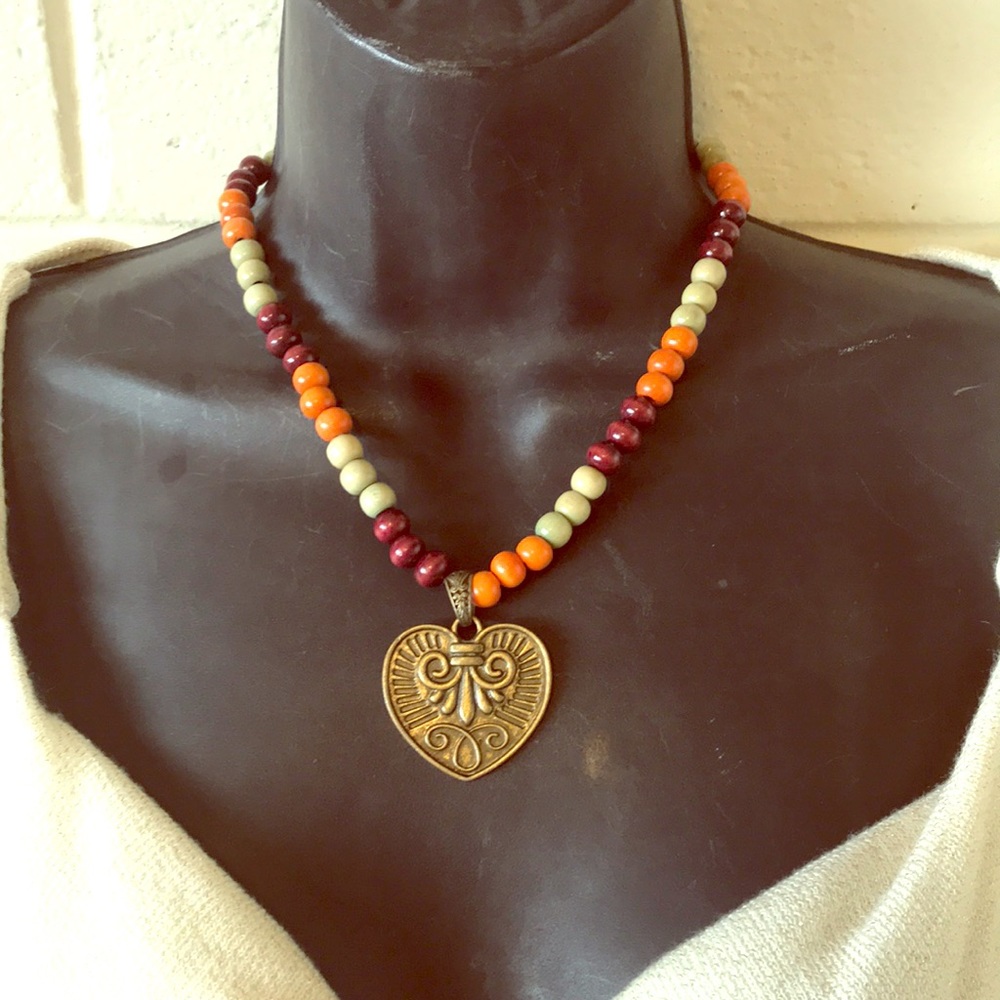 Handmade brass heart necklace made of wooden beads by Amanda Sanchez